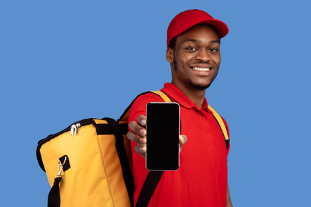 African american courier man showing mobile phone with blank screenの写真素材