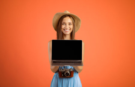 Happy woman traveller holding laptop with blank screenの写真素材