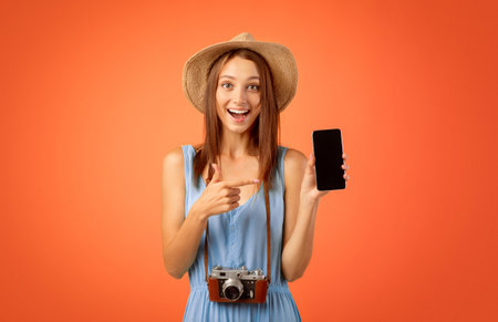 Excited girl tourist pointing at blank mobile phone screen
