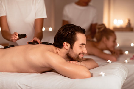 Spouses Relaxing Receiving Exotic Hot Stones Massage In Spaの写真素材
