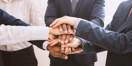 Stacked hands of multiethnic business team, panorama