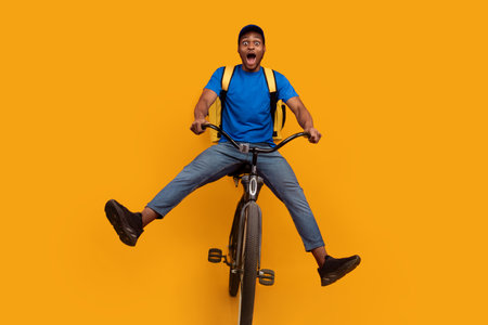 Funny black delivery man riding bicycle at studio