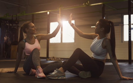 Successful training. Women giving high five, having restの写真素材