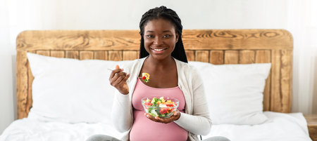 Pregnancy Diet And Nutrition. Pregnant African American Woman Eating Fresh Vegetable Saladの写真素材