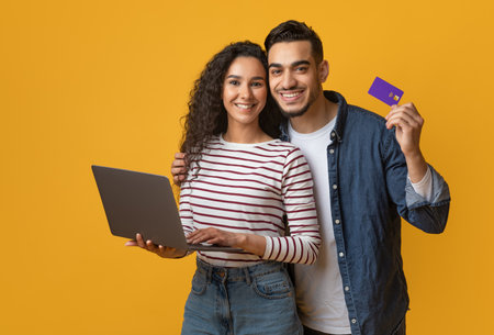 Online Shopping Concept. Happy Arabic Couple Using Credit Card And Laptop