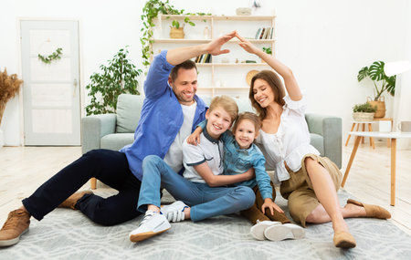 Parents Making Symbolic Roof Joining Hands Above Kids Sitting Indoors