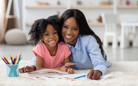 Portrait of cheerful loving mom and little girl coloring togetherの写真素材