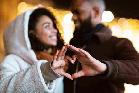 Portrait of african american couple making heart shape with handsの写真素材