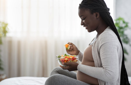 Healthy Diet During Pregnancy. Black Expectant Woman Eating Vegetable Salat At Homeの写真素材