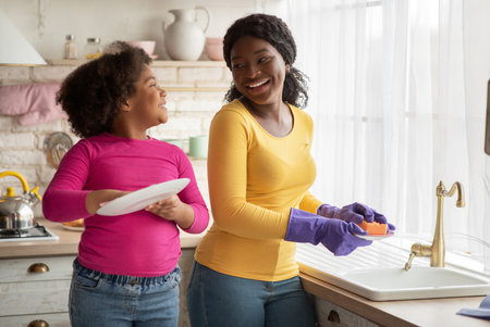 Helping Hand. Cute Little Black Girl Helps Her Mom In Kitchenの写真素材