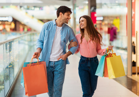 Couple Shopping Carrying Shopper Bags Walking In Modern Hypermarket Indoorの写真素材