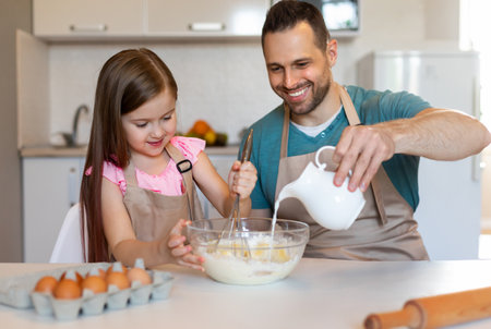 Happy Daughter And Father Making Dough Mixing Ingredients In Kitchen