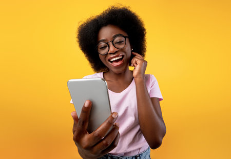 Happy african american lady using smartphone and making video call, smiling at cellphone camera over...