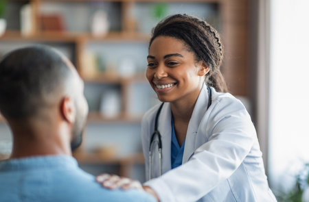 Cheerful african american woman doctor touching male patient shoulderの写真素材