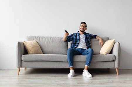 Young Arab guy spending weekend watching tvの写真素材