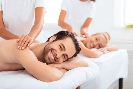 Boyfriend And Girlfriend Lying Enjoying Relaxing Massage At Spa Resortの写真素材