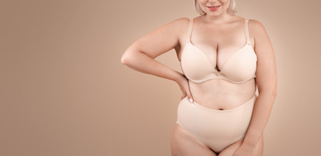 Self Acceptance. Beautiful Curvy Lady In Underwear Posing On Beige Backgroundの写真素材