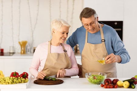 Happy Senior Couple Making Salad Together In Kitchen At Homeの写真素材