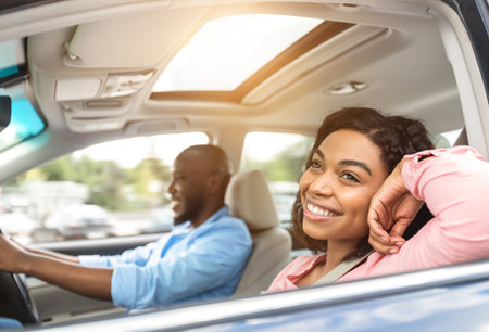 Happy black couple enjoying long drive on a carの写真素材