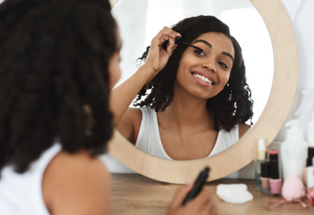 Daily Makeup. Beautiful Black Woman Applying Mascara On Eyelashes At Home
