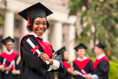 Cheerful african american young lady in graduation costumeの写真素材