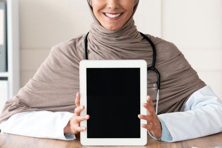 Cheerful female doctor showing digital tablet with blank screenの写真素材