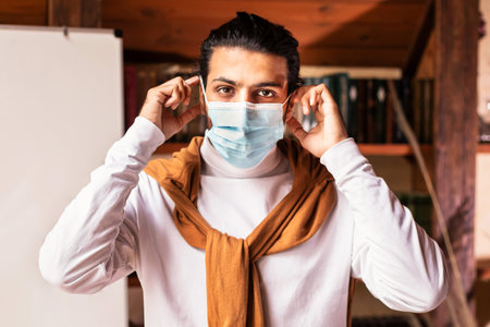 Indian Teacher Man Wearing Face Mask Standing Near Blackboard Indoorsの写真素材