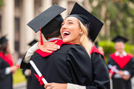 Cheerful blonde lady hugging her boyfriend while graduation ceremony