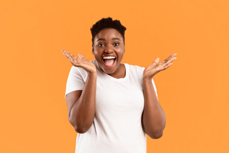 Joyful Black Lady Shouting Omg In Excitement Over Yellow Backgroundの写真素材