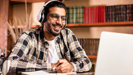 Positive Indian Student Guy At Laptop Learning Online At Homeの写真素材