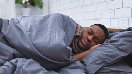 Sick Black Man Sleeping In Bed Having Flu At Homeの写真素材