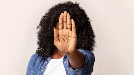 African american woman hiding behind her palmの写真素材
