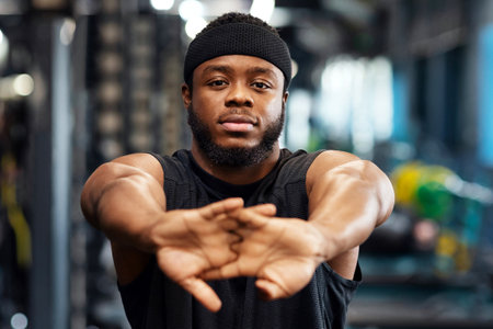 Sportsman stretching his hands before workout training at gymの写真素材