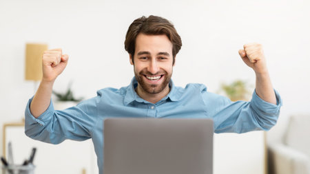 Joyful Businessman At Laptop Celebrating Business Success Sitting In Officeの写真素材