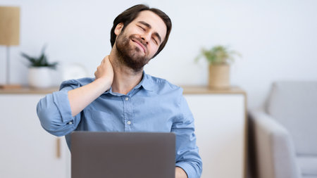 Tired Businessman Massaging Aching Neck Sitting At Laptop In Office