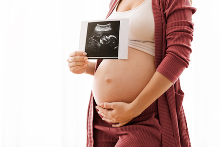 Closeup Shot Of Pregnant Lady Showing Baby Ultrasound Photo And Embracing Belly