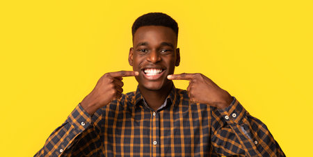 Perfect Smile. Happy Black Guy Pointing At His White Teeth With Fingers