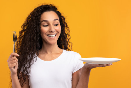 Portrait of Smiling Latin Lady Holding Fork And Plate