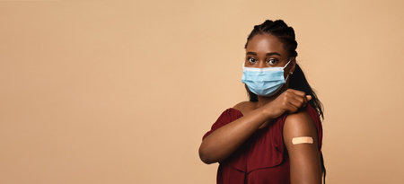 Black lady in protective face mask after vaccination
