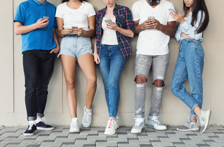 Group of multiculture friends using smartphone on urban background