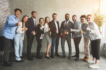Positive interracial business people showing thumbs up