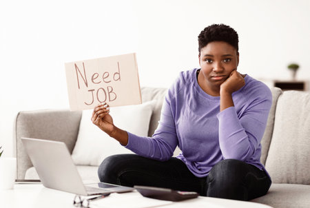 Young sad black woman holding sign Need job