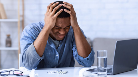 Black Man Suffering From Headache Touching Head Sitting At Workplaceの写真素材