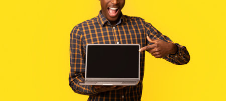 Check This Website. African Guy Pointing At Laptop Computer With Black Screenの写真素材
