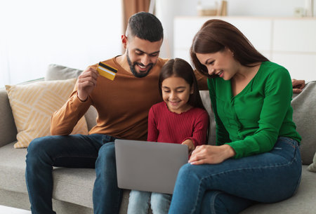Arabic family using computer and credit card at homeの写真素材