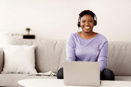 Black woman sitting, looking to camera wearing headset