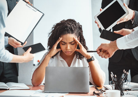 Overworked Afro Businesswoman Sitting Tired Of Multitasking In Modern Office