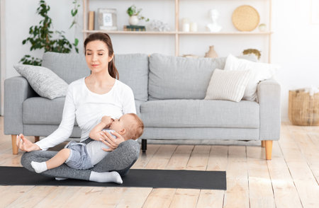 Coping With Motherhood Stress. Young Mom Breastfeeding Baby And Meditating At Homeの写真素材