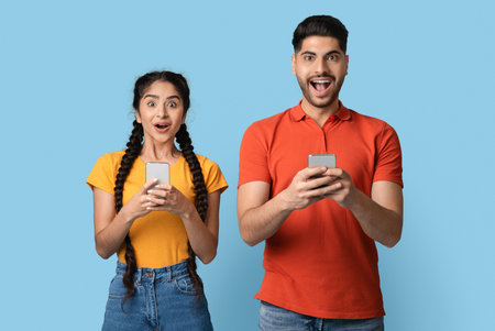 Mobile Offer. Portrait Of Happy Shocked Arab Couple With Smartphones In Hands
