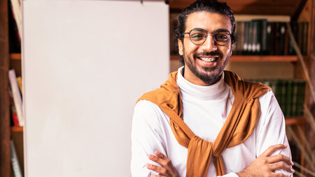 Smiling Indian Teacher Guy Posing Near Blackboard Standing At Home